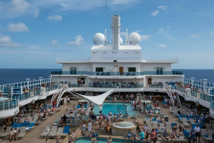 Crowded cruise ship deck with swimming pools under a blue sky, setting for scariest true stories