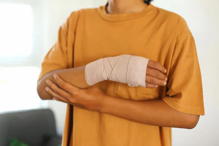 A person with a bandaged hand, a reminder of the physical elements in scariest true stories.