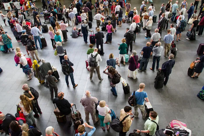 A large crowd of travelers waiting with luggage, evoking the beginning of mysterious scariest true stories