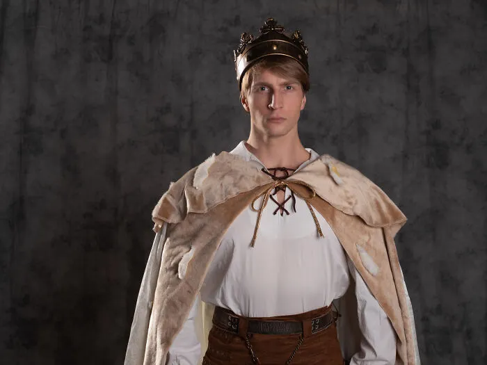 A man in a king costume and crown posing, perfect for quick-fire jokes.