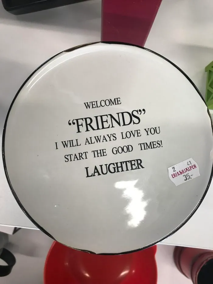 A round ceramic plate with inspirational text featuring misused quotation marks around the word friends.