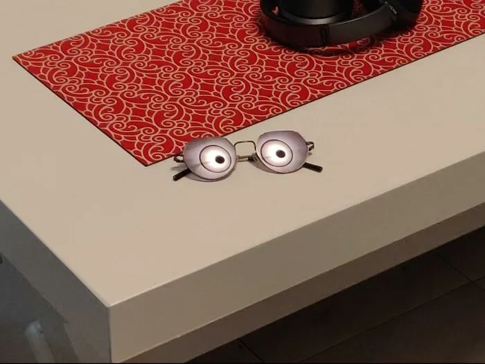 Eyeglasses reflecting ceiling lights that look like cartoon eyes on a table, perfectly confusing photos.