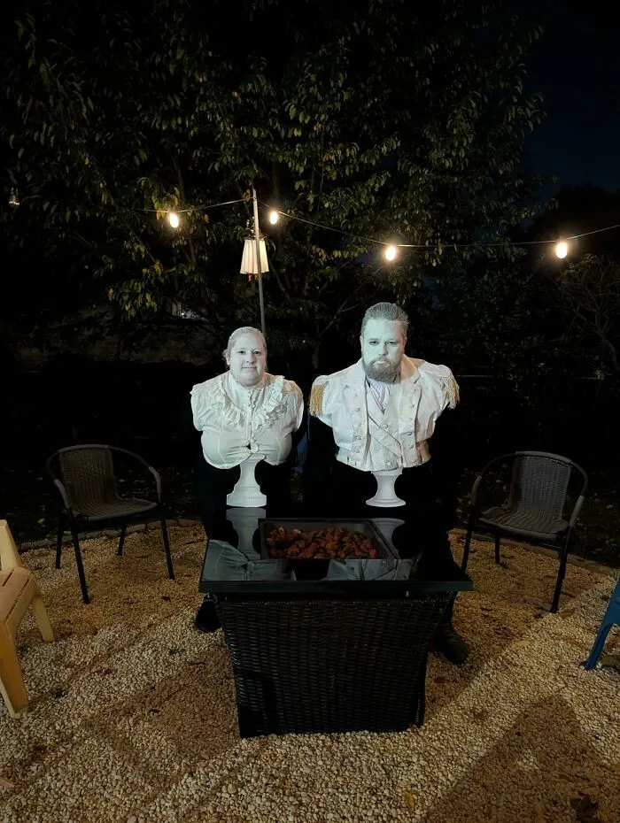 Couple dressed up as living white busts for a creative Halloween costume idea.