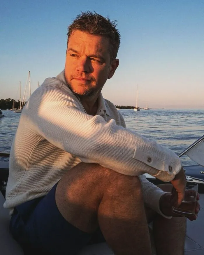 Matt Damon sitting on a boat at sunset, looking out while sharing true stories.