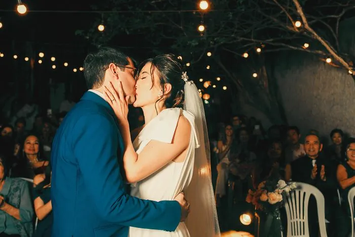 A bride and groom kissing at their wedding reception, reflecting unethical life pro tips for saving on events