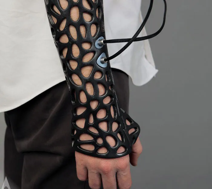 A black 3D printer arm cast with stylish open-mesh pattern worn on a forearm