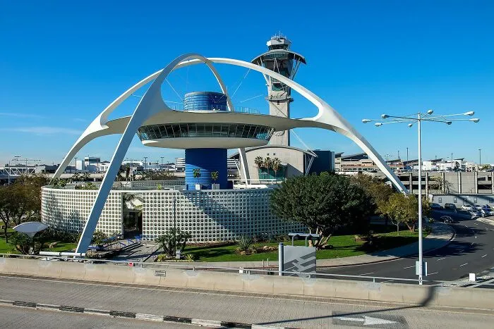 Unique strange building with futuristic arches and control tower in background