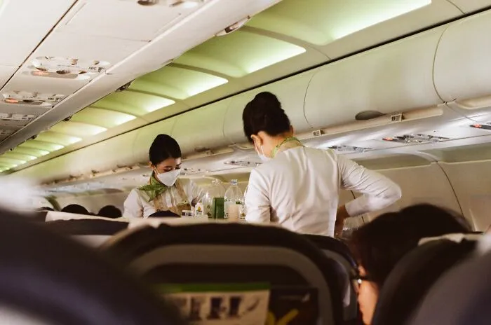 Flight attendants serving passengers inside airplane cabin
