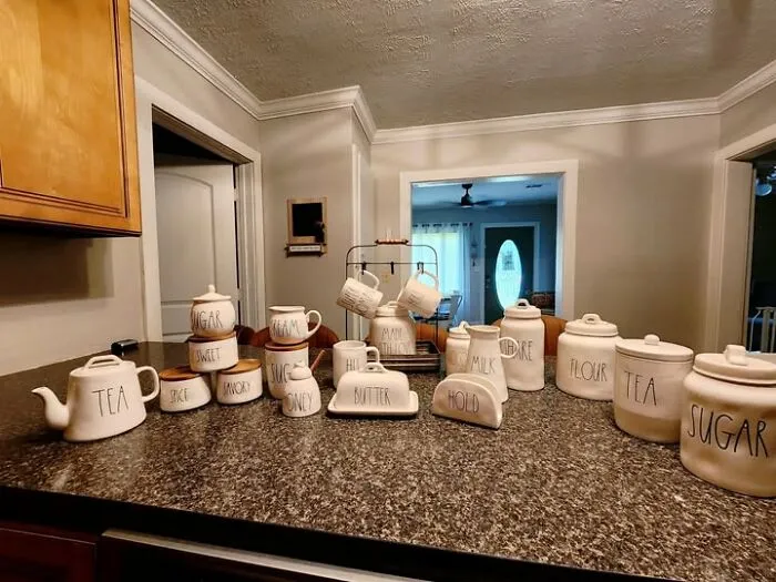 Collection of Rae Dunn white ceramic kitchen canisters and teapots found while thrifting