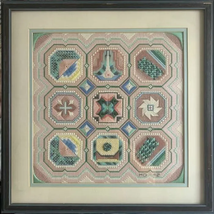 Framed geometric needlepoint artwork featuring pastel patterns, a unique thrift find framed display