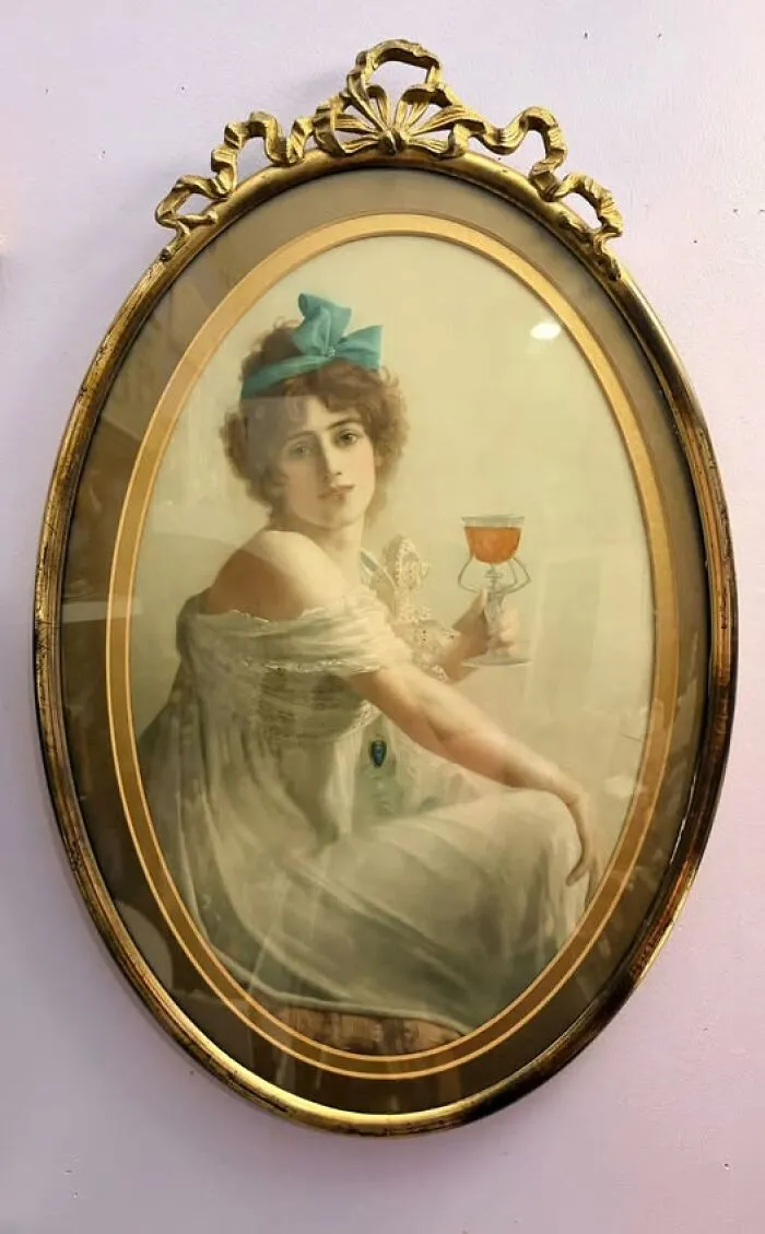 Framed vintage portrait of a woman holding a glass, a classic thrift find.
