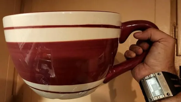 Hand holding an oversized striped coffee mug, an unusual thrift find