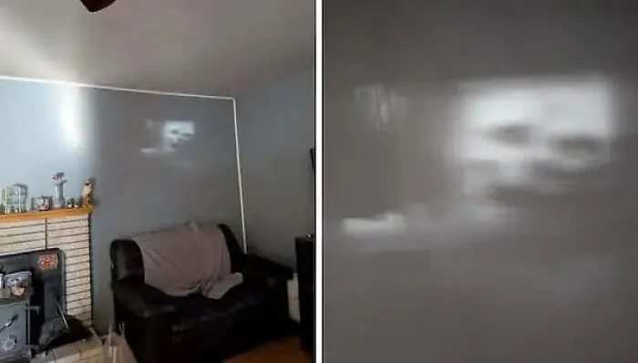 A spooky reflection on a living room wall resembling a face, one of many cursed images.