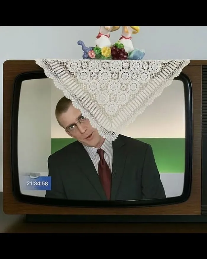Funny photo of a news anchor on a retro TV screen covered by a lace doily.