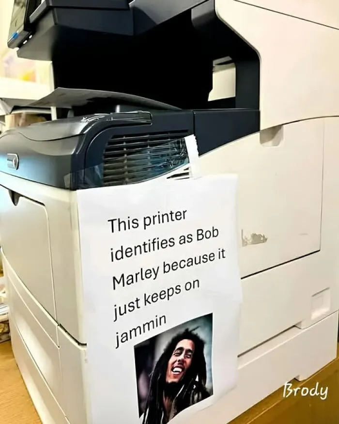 A funny note on an office printer stating it identifies as Bob Marley, from interesting photos.