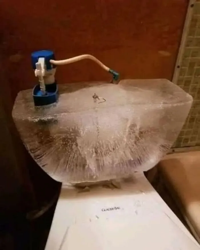 Toilet water tank completely frozen into a solid block of ice, one of many odd photos.
