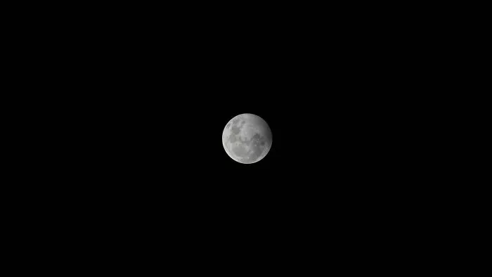 A full moon glowing against a dark night sky, connected to natural human body facts and cycles.