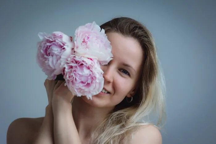 A woman holding flowers near her face exploring human body facts and senses