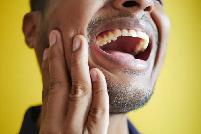 A man pointing to his teeth showing human body facts