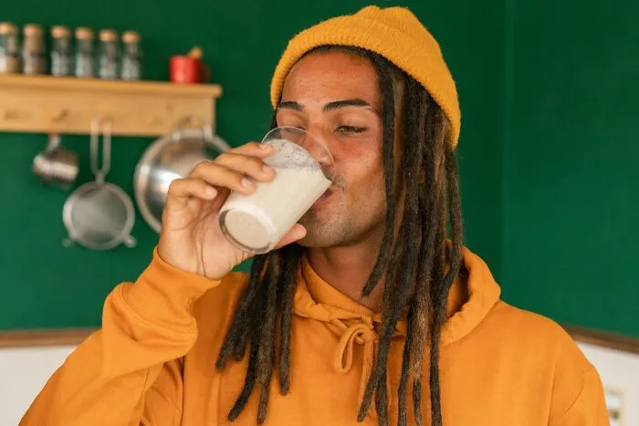 A man drinking a glass of milk in an office, showcasing weird colleagues at work