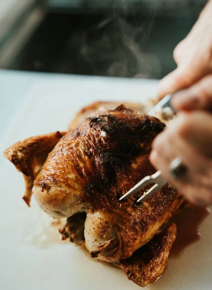 A person carving a whole roasted chicken, representing weird habits at work
