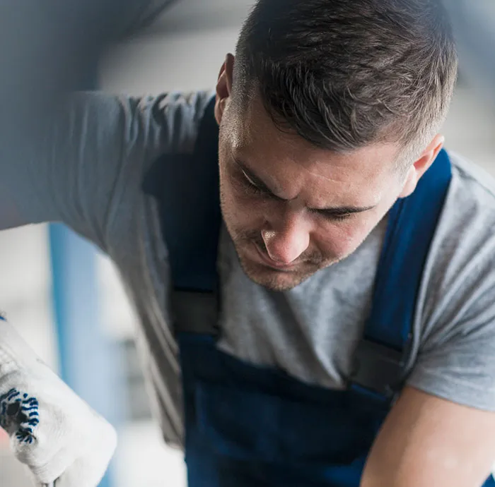 Focused mechanic working intensely illustrating demanding repair jobs