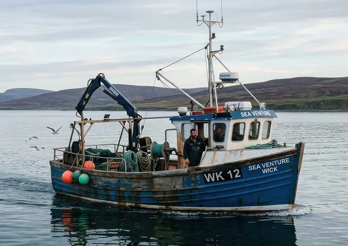 Fishing boat at sea illustrating dangerous jobs with high pay in fishing industry