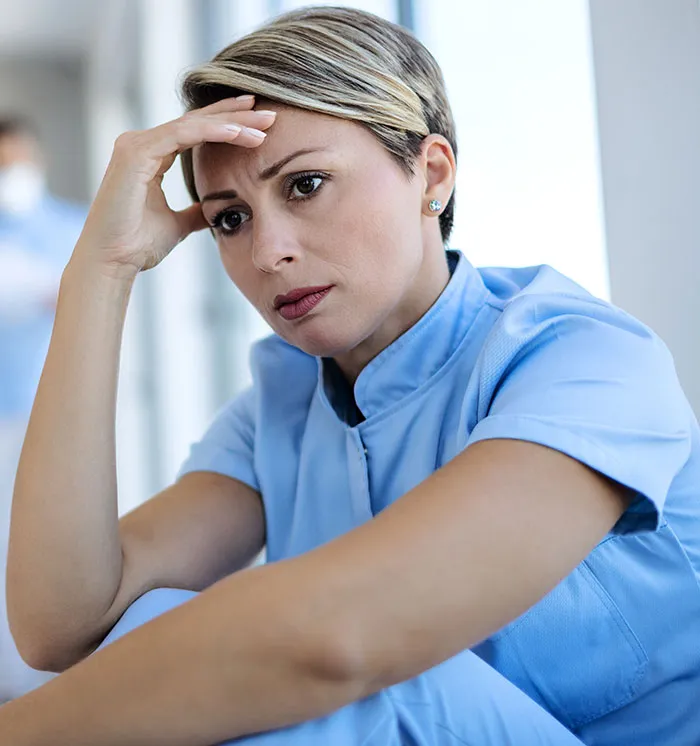 Stressed nurse in scrubs showing pressure of high paying dangerous jobs