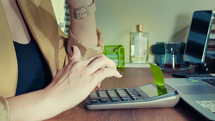 Person calculating finances in stressful office job