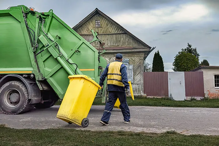 Garbage collector working with trash truck in dangerous job with high pay