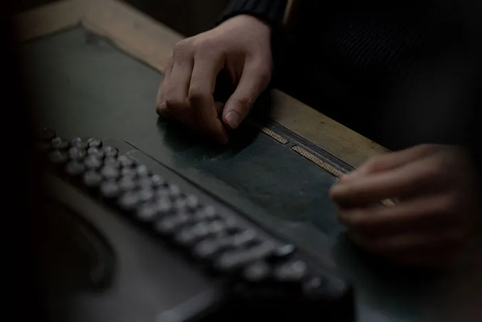 Person working with braille typewriter in a specialized transcription job