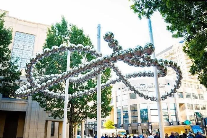A bizarre public art sculpture consisting of a giant ring of reflective metallic spheres in a plaza