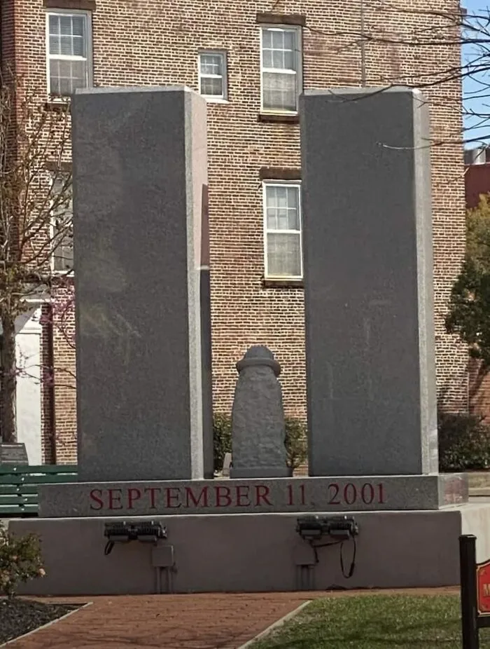 A minimalist public art monument depicting the World Trade Center towers with September 11, 2001 inscribed.