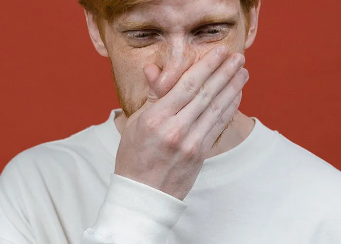 Man covering nose in disgust illustrating haunted house worker reactions