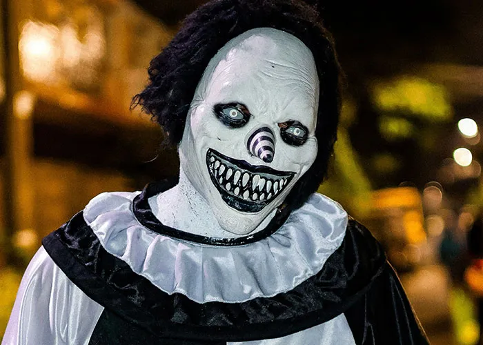 Sinister clown mask with eerie smile at haunted house attraction