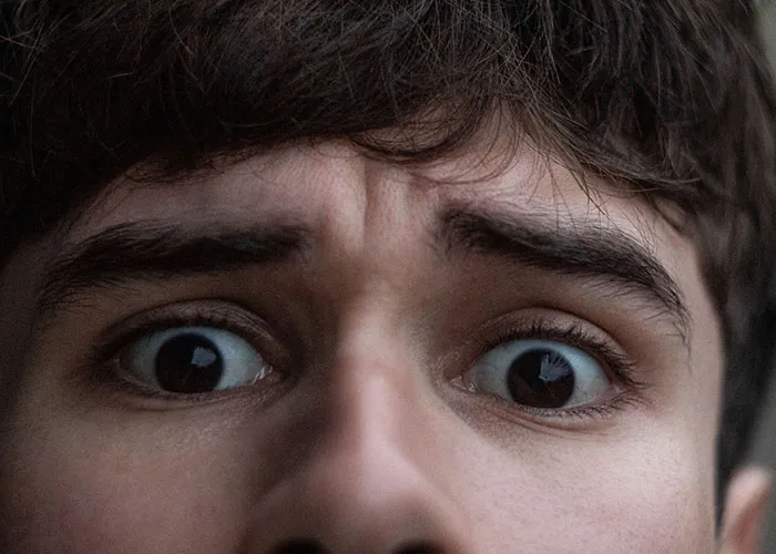 Close-up of scared person with wide eyes in haunted house experience