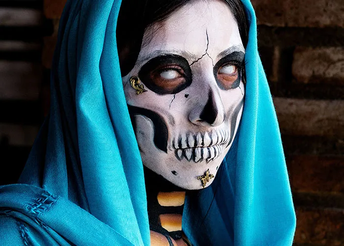Person in eerie skull makeup costume for haunted house event