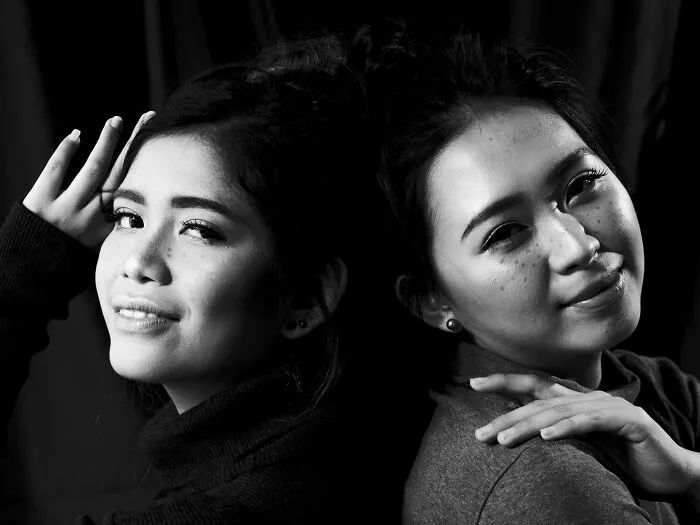 Two women posing back to back in a black and white portrait for hilarious BF phone discoveries