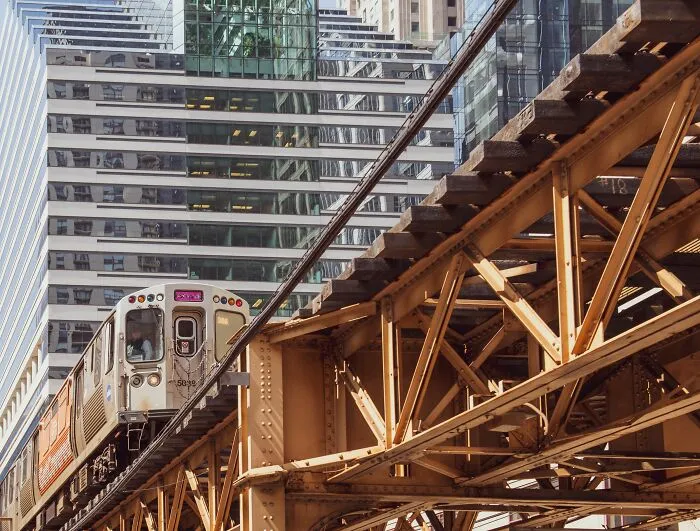 An elevated train travelling through a modern city, representing stories of people behaving like the world owed them everything