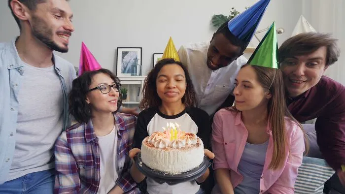 Friends gather for a birthday cake, showing how people behaving like the world owed them everything can ruin happy moments.