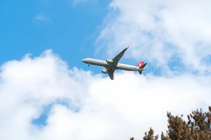 Turkish Airlines airplane flying high in the blue sky with clouds, highlighting experiences of people behaving entitled