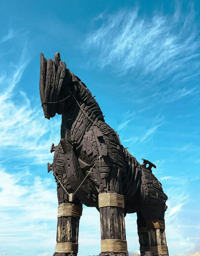 Wooden Trojan horse sculpture under blue sky