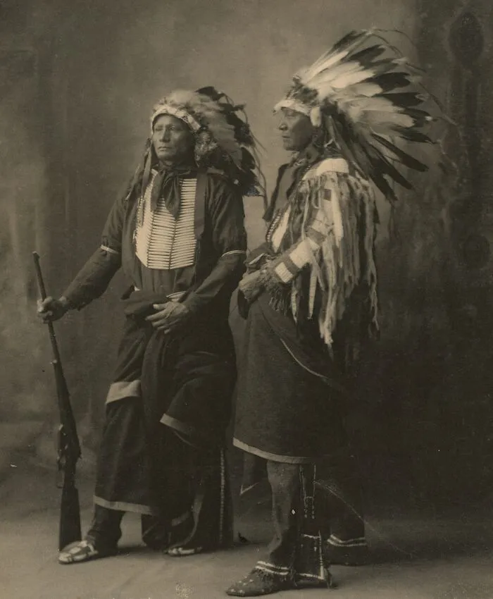 Historic portrait of Native American men wearing traditional headdresses