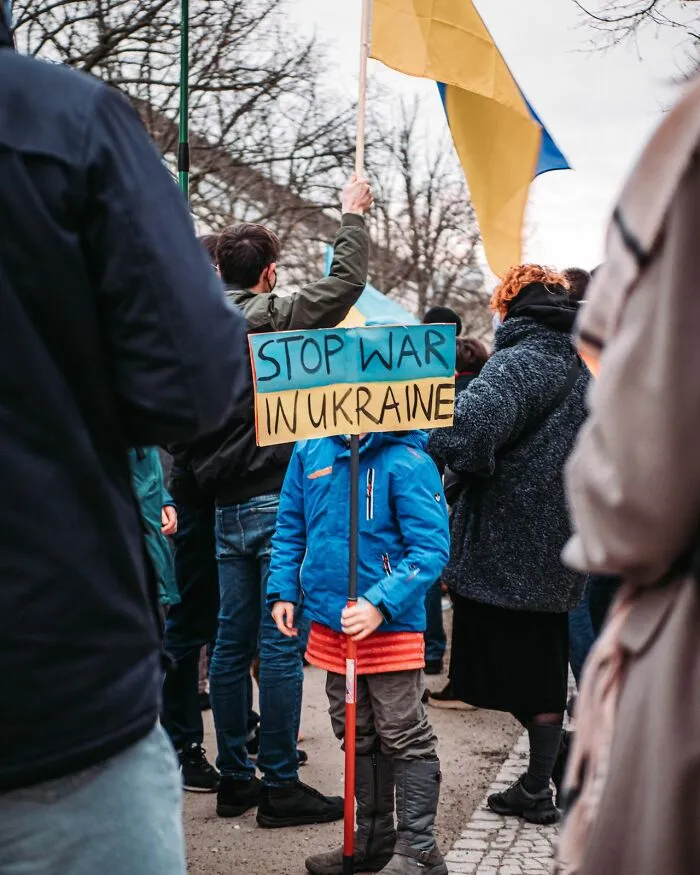 Child holding stop war in Ukraine protest sign at rally