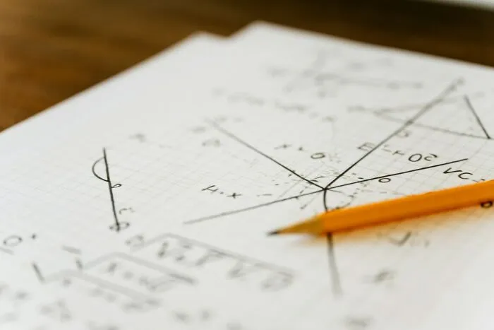 Handwritten math equations on graph paper with a yellow pencil to make your everyday life easier
