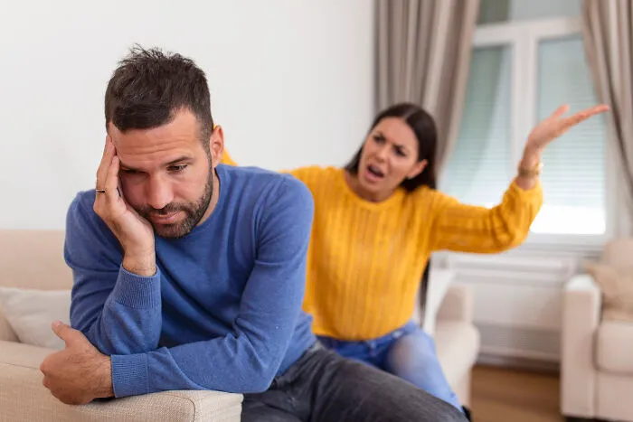 Frustrated couple arguing at home, illustrating a conflict that could get someone disowned