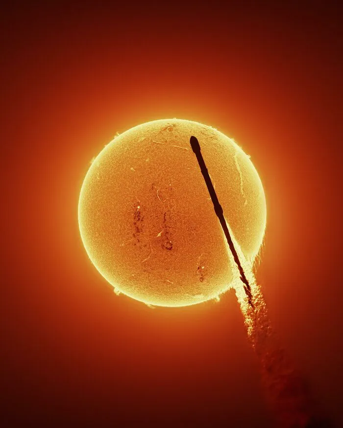 An interesting photo of a rocket silhouette passing in front of the sun