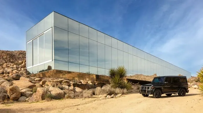 Modern strange building with reflective glass walls in desert landscape