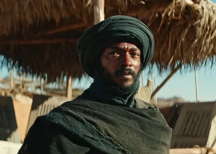 One of the Hollywood stars wearing a turban and dark robe in a desert setting.
