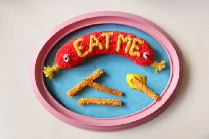 Tufted hot dog art with french fries in a pink frame by Ina Dyreborg
